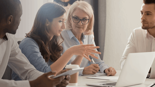 Four people in discussion sitting at desk