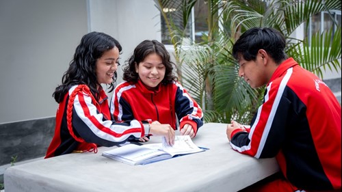 A group of school students looking a a text book