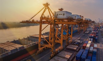 A shipyard loading a large container ship with cargo