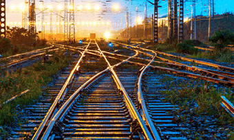 Railroad tracks lead into the horizon at dusk