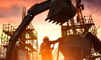 Construction workers silhouetted against a vibrant sunset