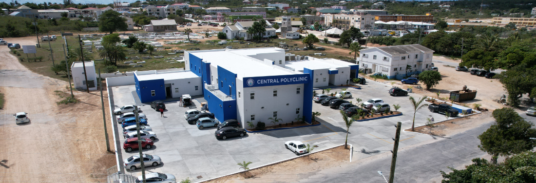 Aerial shot of a blue building with cars arranged in front